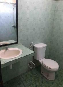 a bathroom with a toilet and a sink and a mirror at Gina's guest house in Sanur