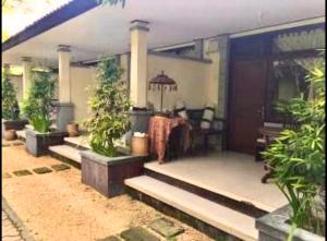 a porch of a house with potted plants at Gina's guest house in Sanur