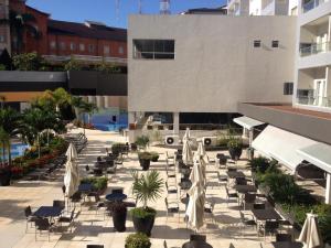 un patio esterno con sedie e ombrelloni di Flat Veredas do Rio Quente - apto com vista para piscinas a Rio Quente
