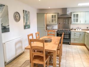 a kitchen with a wooden table and chairs at 85 Seatown in Cullen