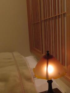 大牟田市にある旅館 清風荘のベッド横のテーブルに座るランプ