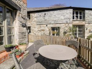 a patio with a table and chairs and a fence at The Old Smithy in Saint Columb Major