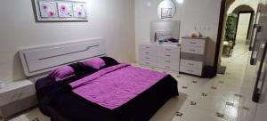 a bedroom with a purple bed and a mirror at شقة عائلية -ليست فندقية- 8 دقائق بالسيارة للحرم أو قباء - in Al Madinah