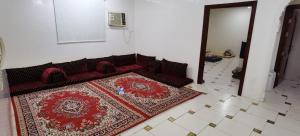 a living room with a red couch and a rug at شقة عائلية -ليست فندقية- 8 دقائق بالسيارة للحرم أو قباء - in Al Madinah +2 photos