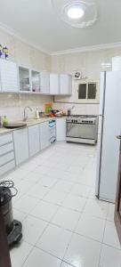 a kitchen with white appliances and a white tile floor at شقة عائلية -ليست فندقية- 8 دقائق بالسيارة للحرم أو قباء - in Al Madinah