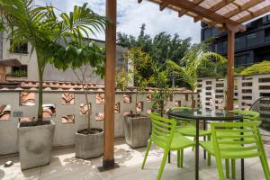 a patio with a table and chairs and plants at Soy Local Primavera in Medellín