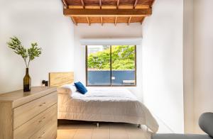 a bedroom with a bed and a window at Soy Local Primavera in Medellín