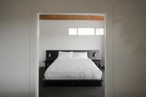 a bedroom with a bed with white sheets and a window at Hollywood Hills Hotel in Los Angeles