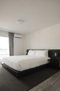 a bedroom with a large bed with white sheets at Hollywood Hills Hotel in Los Angeles