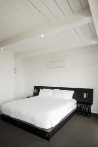 a white bed with a black headboard in a room at Hollywood Hills Hotel in Los Angeles
