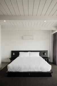 a bedroom with a large white bed with two tables at Hollywood Hills Hotel in Los Angeles