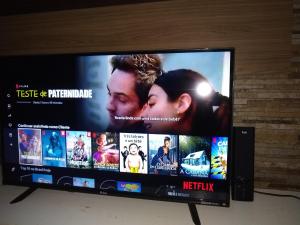 a flat screen tv with many movies on it at Casa da Andrea Imbassai in Imbassai