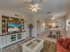 a living room with a television and a dining room at Beachcomber Beach House - Weekly Rental Just Steps to White Sand Beach! home in Clearwater Beach