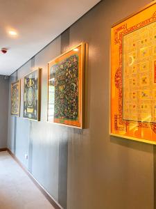 a hallway with three paintings on the wall at UNWND Flats in Manila
