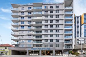 um edifício branco alto com um sinal que lê o coentro em The Capitol Apartments em Brisbane