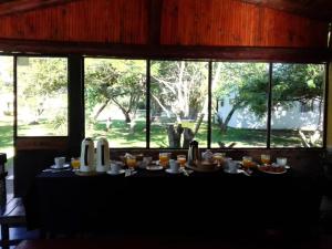 uma mesa com comida numa sala com janelas em EL PASO IBERA em Colonia Carlos Pellegrini
