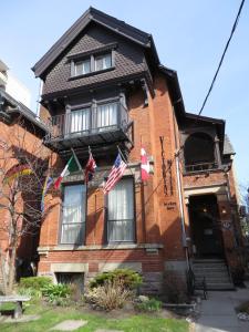 une maison en briques rouges arborant des drapeaux américains dans l'établissement Victoria's Mansion Guest House, à Toronto