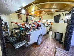 a truck with a motorcycle in the back of a garage at Hostal Rosita Latacunga in Latacunga