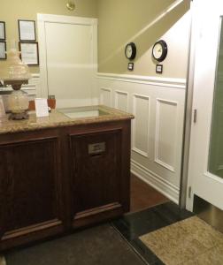 a room with a counter and clocks on the wall at Victoria's Mansion Guest House in Toronto