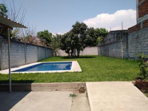 a backyard with a swimming pool in the grass at Aquetzali Kin Casa Privada con alberca in Cuautla Morelos