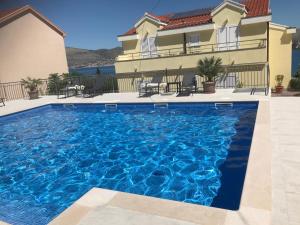 a swimming pool in front of a house at Villa Luna in Trogir