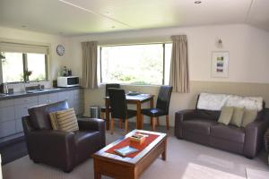 Burn Cottage Retreat في كرومويل: غرفة معيشة مع أريكة وطاولة