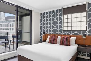 Llit o llits en una habitació de Mantra Sydney Central