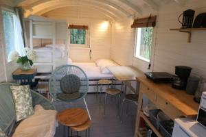 Habitación pequeña con cama en una casa pequeña en Pipowagen Jasmijn bij Pipowagen en kampeerhoeve s Gravenhof en Netterden
