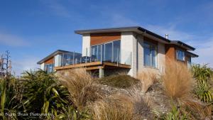 a house on the beach with glass at Hillcrest Lodge B - Lake Tekapo in Lake Tekapo