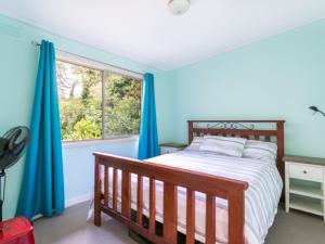 a bedroom with a bed with blue walls and a window at Summer In Blairgowrie in Blairgowrie