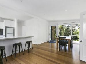 a kitchen and dining room with a table and chairs at Woodlands Retreat Rye in Rye +3 photos