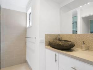 a bathroom with a stone sink and a shower at Woodlands Retreat Rye in Rye