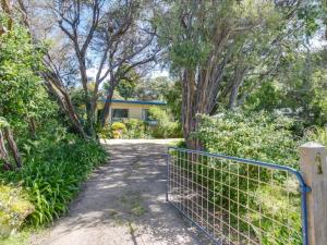 a gate in front of a house with trees at Woodlands Retreat Rye in Rye