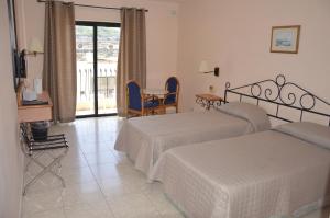 a hotel room with two beds and a table at Porto Azzurro Aparthotel in St. Paul's Bay