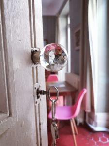 a door knob with a pink chair and a mirror at Les Chambres des Barques in Narbonne