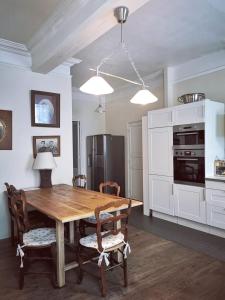 a kitchen with a wooden table and chairs at Les Chambres des Barques in Narbonne