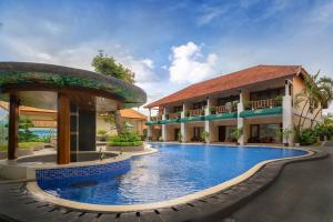 a hotel with a swimming pool in front of a building at New Sunari Lovina Beach Resort in Lovina