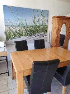 una sala da pranzo con tavolo e sedie in legno di Atlantis 1-Wohnung Nr 8 a Grossenbrode
