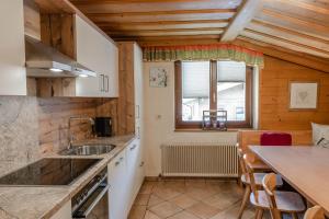 eine Küche mit einem Waschbecken und einem Tisch mit Stühlen in der Unterkunft Ferienhaus Höllwart in St. Johann im Pongau