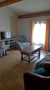sala de estar con mesa de centro y sofá en Charmant appartement dans corps de ferme AIGLUN, en Aiglun