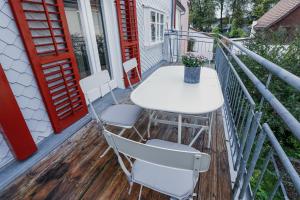 einen weißen Tisch und Stühle auf dem Balkon in der Unterkunft HEINRICH Stadtwohnung im Jüdischen Viertel in Hohenems