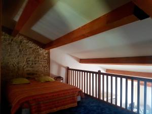 1 dormitorio con cama y pared de piedra en Charmant appartement dans corps de ferme AIGLUN, en Aiglun