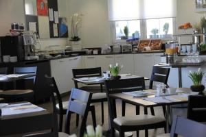 a restaurant with tables and chairs and a kitchen at Businesshotel Lux in Lucerne