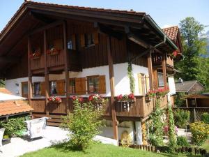 een groot huis met houten balkons en bloemen bij Ferienwohnung Hinterstoißer in Berchtesgaden