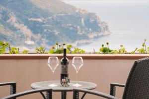 una botella de vino sentada en una mesa con dos copas en A Due Passi, en Ravello