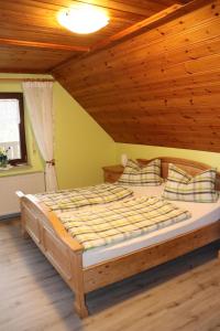 a bed in a room with a wooden ceiling at Zur Altmühlquelle in Windelsbach