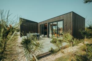 a house on the beach with a wooden deck at Vakantiepark De Klepperstee in Ouddorp