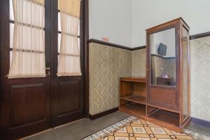 een lege kamer met een deur en een tv bij RedDoorz Syariah @ Kolonial Guest House in Majalengka