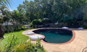 a swimming pool in a yard with two pillows at Waterloo Guest House in Durban