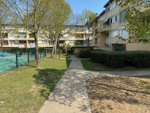 a walkway in a park next to a building at Chambre (Pluton) - Proche gare TGV et PARIS in Massy